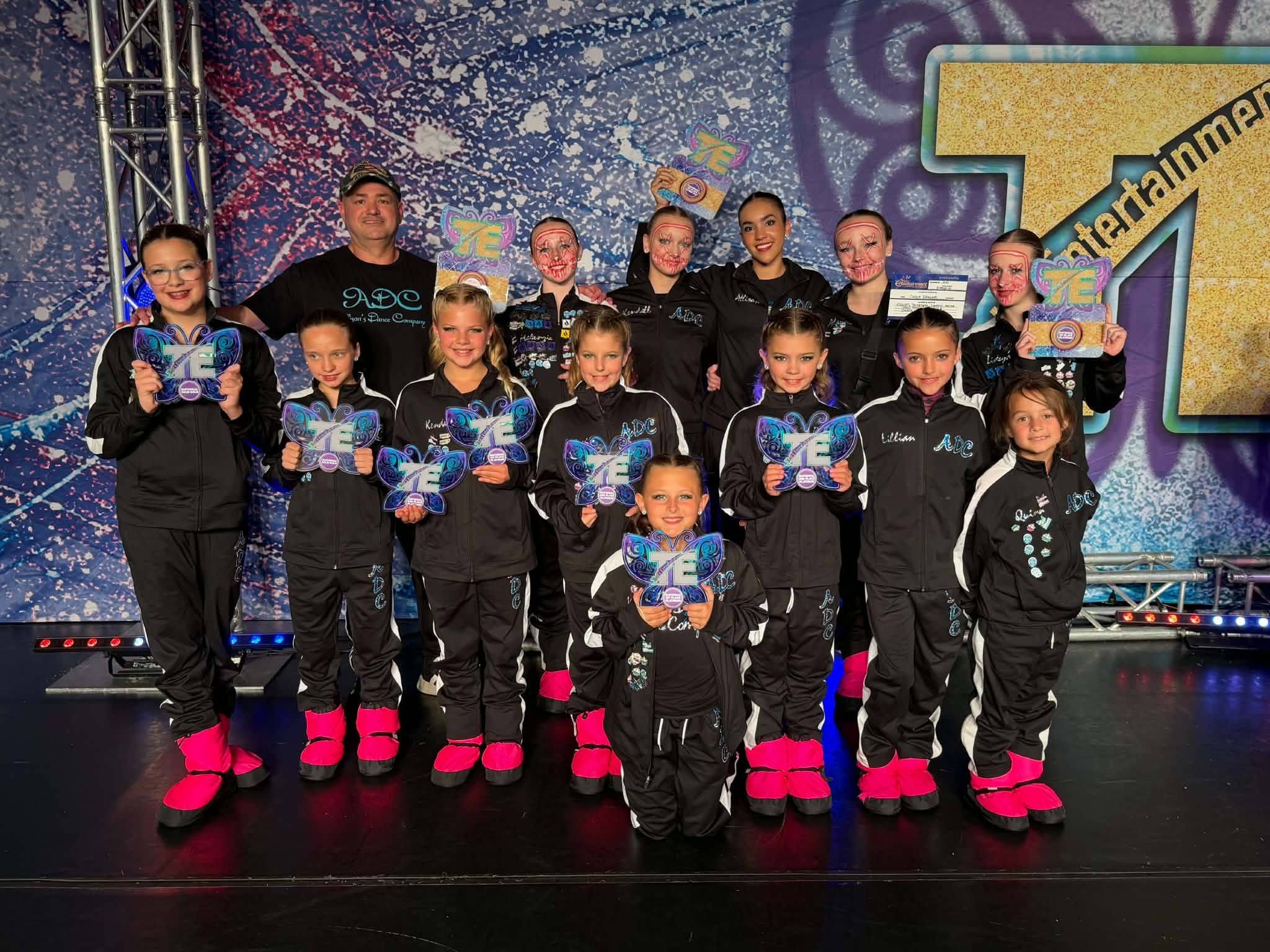 Allison's Dance Company competition team celebrating together on stage